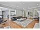 Open-concept living area with hardwood floors and a modern black sofa, perfect for relaxing and entertaining guests at 602 Embassy Ct, Peachtree City, GA 30269