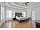 Bright main bedroom with hardwood floors, tray ceiling, and sheer window treatments at 602 Embassy Ct, Peachtree City, GA 30269