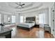 Bright main bedroom with hardwood floors, tray ceiling, and sheer window treatments at 602 Embassy Ct, Peachtree City, GA 30269