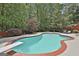Relaxing backyard pool with a diving board, surrounded by mature trees, offering privacy and a serene atmosphere at 602 Embassy Ct, Peachtree City, GA 30269