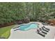 Aerial view of a private pool with a diving board and lounge chairs surrounded by lush greenery and trees at 602 Embassy Ct, Peachtree City, GA 30269