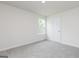 A sunlit bedroom with soft carpet, a window, and a closet at 285 Limestone Circle, Conyers, GA 30013