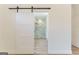Bathroom featuring a modern sliding barn door that leads to a glass-enclosed shower with marble tile at 4731 H D Atha Rd, Covington, GA 30014