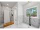 Modern bathroom showcasing marble tile, a glass shower enclosure, and large window with natural light at 4731 H D Atha Rd, Covington, GA 30014