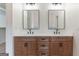 Bathroom featuring dual sinks, wood cabinets, black fixtures, and large square mirrors at 4731 H D Atha Rd, Covington, GA 30014