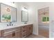 Bathroom featuring dual sinks, wood cabinets, black fixtures, and an arched doorway to another room at 4731 H D Atha Rd, Covington, GA 30014