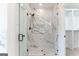 Bathroom featuring a shower with glass doors, marble tile, and modern fixtures next to a walk-in closet at 4731 H D Atha Rd, Covington, GA 30014