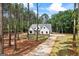 Well-designed home with a long driveway and landscaping, nestled among mature trees, offers privacy and curb appeal at 4731 H D Atha Rd, Covington, GA 30014