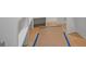 A hallway shows wood flooring, white trim, and blue painters tape prepping for final coat at 4731 H D Atha Rd, Covington, GA 30014