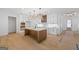 A spacious kitchen featuring white cabinets, a center island with stone countertops and modern light fixtures at 4731 H D Atha Rd, Covington, GA 30014