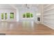 Bright living room featuring hardwood floors, stone fireplace, large windows and a ceiling fan at 4731 H D Atha Rd, Covington, GA 30014