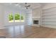Bright living room with a stone fireplace, built-in bookshelves, and large windows overlooking trees at 4731 H D Atha Rd, Covington, GA 30014