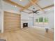 Open living room with wood beam ceiling, fireplace, built-in shelves, and large windows offering natural light at 4731 H D Atha Rd, Covington, GA 30014