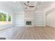 Bright living room with stone fireplace, built-in bookshelves, and large windows at 4731 H D Atha Rd, Covington, GA 30014