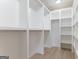 Large walk-in closet with white shelving, metal rods, and hardwood floors, offering ample storage space at 4731 H D Atha Rd, Covington, GA 30014