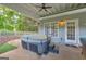 Covered back porch with a hot tub, ceiling fan, seating, and privacy, creating a secluded relaxation space at 4985 Rolling Rock Dr., Sugar Hill, GA 30518