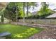 Spacious backyard featuring artificial turf, wooden fences, and mature trees at 4985 Rolling Rock Dr., Sugar Hill, GA 30518