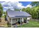 Spacious backyard featuring a covered patio with seating, hot tub, and well-maintained lawn at 4985 Rolling Rock Dr., Sugar Hill, GA 30518