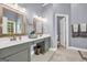 This bathroom has grey walls, a grey vanity with a white counter and 2 mirrors at 4985 Rolling Rock Dr., Sugar Hill, GA 30518