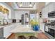 Bright kitchen with white cabinetry, stainless steel appliances, granite countertops and a central island with cooktop at 4985 Rolling Rock Dr., Sugar Hill, GA 30518