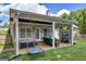 Covered patio with hot tub, lounge seating, and outdoor TV, perfect for outdoor relaxation at 4985 Rolling Rock Dr., Sugar Hill, GA 30518