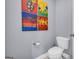 This powder room has grey walls, a toilet and colorful artwork at 4985 Rolling Rock Dr., Sugar Hill, GA 30518