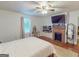 Bright bedroom features a brick fireplace, large window, and comfortable furnishings at 75 Grady Smith St, Grantville, GA 30220