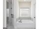 Bathroom featuring a shower, a bathtub, gray tile, and black fixtures at 481 Cantrell Drive, Dallas, GA 30157