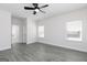 Spacious bedroom with gray flooring, a fresh coat of white paint, a ceiling fan, and two windows at 481 Cantrell Drive, Dallas, GA 30157
