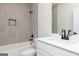 Modern bathroom featuring a shower over tub with gray tile and a sleek white vanity with black hardware at 539 Cantrell Drive, Dallas, GA 30157