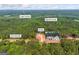 Expansive aerial view of new home with mature trees, Lake Varner and Big Flat Creek in Covington, GA at 4751 H D Atha Rd, Covington, GA 30014
