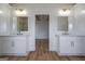 Modern bathroom with double vanity, framed mirrors, gold hardware, wood floors, and view to bedroom at 4751 H D Atha Rd, Covington, GA 30014