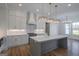 Modern kitchen with white cabinets, a large island, and elegant lighting fixtures at 4751 H D Atha Rd, Covington, GA 30014