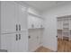 Functional laundry room featuring white cabinets with black hardware and view to walk-in closet at 4751 H D Atha Rd, Covington, GA 30014