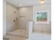 Modern shower boasts neutral tiling, stylish fixtures, a mosaic-tiled niche, and natural light from the window at 4751 H D Atha Rd, Covington, GA 30014