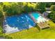 Aerial view of the community pool, playground, and basketball court, surrounded by lush green trees and landscaping at 205 N Strathmore Dr, Sharpsburg, GA 30277
