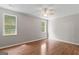 Spacious bedroom featuring hardwood floors, neutral paint, ceiling fan, and natural light from two windows at 205 N Strathmore Dr, Sharpsburg, GA 30277