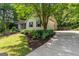 Exterior angle of a charming home with a driveway and landscaped side yard, framed by lush greenery at 205 N Strathmore Dr, Sharpsburg, GA 30277
