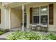 Charming front porch featuring decorative shutters, chairs, and lush greenery, creating an inviting entrance at 205 N Strathmore Dr, Sharpsburg, GA 30277