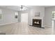 Bright living room featuring a fireplace, tile floors, and views to the adjacent flex space and backyard at 205 N Strathmore Dr, Sharpsburg, GA 30277