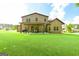 Expansive backyard features a well-manicured lawn, covered patio, and brick exterior of the home at 2589 Lake Erma Dr, Hampton, GA 30228