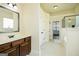 Bathroom with wood vanity and tile floors leading to an enclosed shower and walk-in closet at 2589 Lake Erma Dr, Hampton, GA 30228
