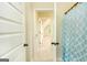 Bathroom view from doorway featuring blue patterned shower curtain and view into the hallway at 2589 Lake Erma Dr, Hampton, GA 30228