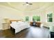 Spacious bedroom with tray ceiling, hardwood floors, and natural light from large windows at 2589 Lake Erma Dr, Hampton, GA 30228