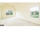 Spacious bedroom with a vaulted ceiling, neutral carpet, and two windows with neighborhood views at 2589 Lake Erma Dr, Hampton, GA 30228