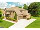 Elegant brick home featuring a three-car garage, well-maintained lawn, and tasteful landscaping at 2589 Lake Erma Dr, Hampton, GA 30228