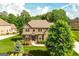 Beautiful two-story brick home with lush landscaping and a well-manicured lawn from an aerial view at 2589 Lake Erma Dr, Hampton, GA 30228