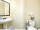 Charming powder room featuring a pedestal sink, decorative mirror, and stylish toilet decor at 2589 Lake Erma Dr, Hampton, GA 30228