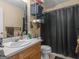 This bathroom has a single sink with storage shelfing and a dark, privacy shower curtain at 140 Joshua St, Palmetto, GA 30268