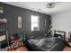 An edgy bedroom featuring a dark accent wall, quirky decor, and a modern ceiling fan at 140 Joshua St, Palmetto, GA 30268